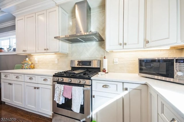 kitchen with white cabinetry, appliances with stainless steel finishes, backsplash, and wall chimney exhaust hood