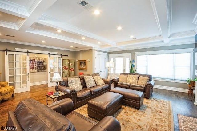 living room featuring beamed ceiling, ornamental molding, and a barn door