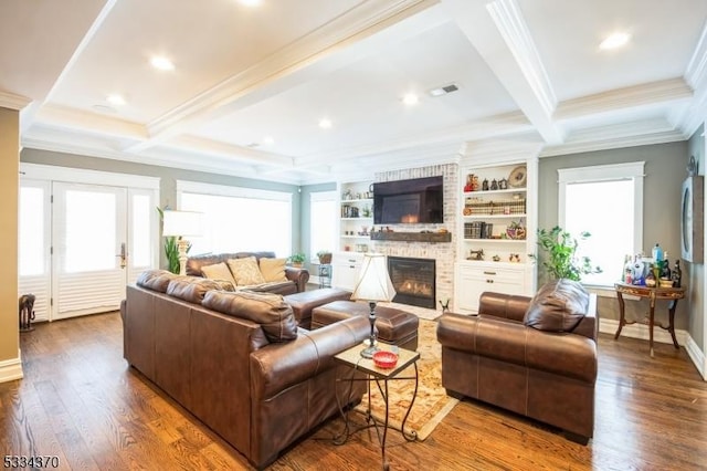 living room featuring beamed ceiling, dark wood-type flooring, a wealth of natural light, and a fireplace