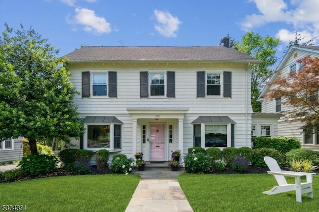 colonial-style house featuring a front lawn