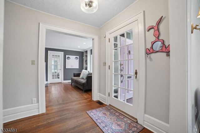 entryway with hardwood / wood-style flooring and ornamental molding