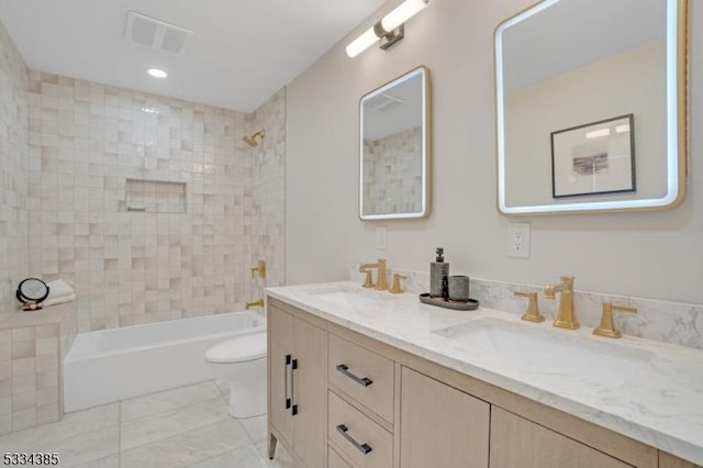 full bathroom featuring vanity, tiled shower / bath combo, tile patterned floors, and toilet