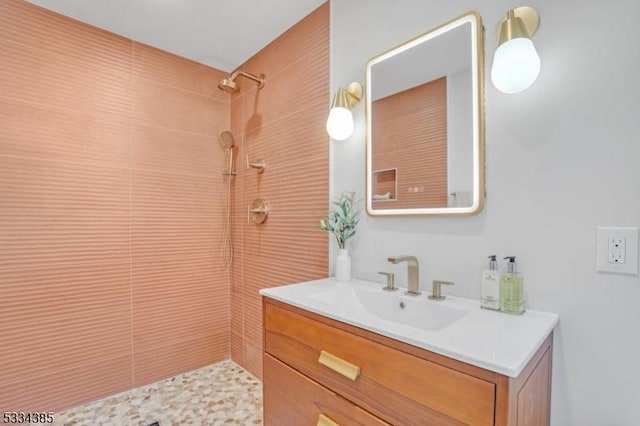 bathroom featuring vanity and tiled shower