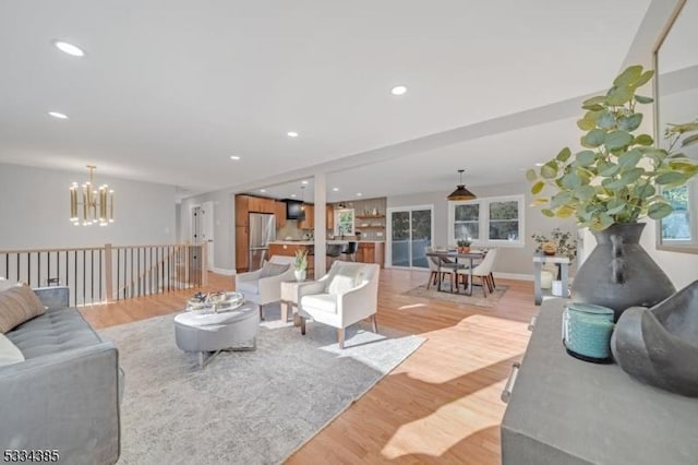 living room featuring a notable chandelier and light wood-type flooring