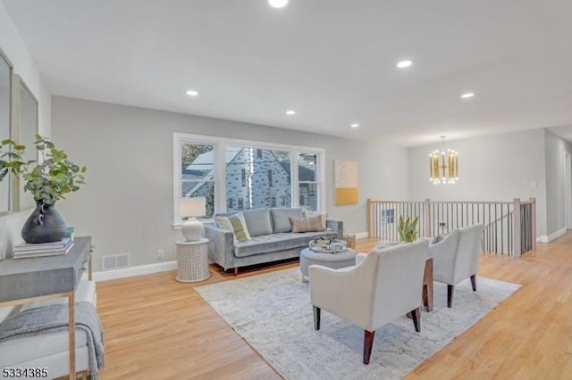 living room featuring a notable chandelier and light hardwood / wood-style floors