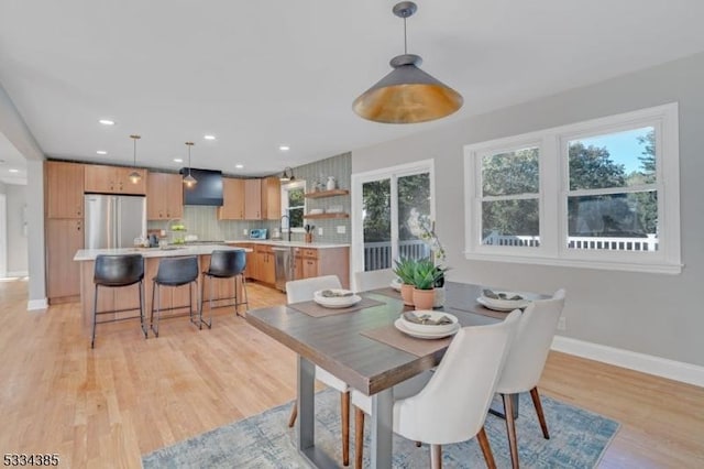 dining space with sink and light wood-type flooring