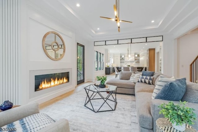 living room featuring light hardwood / wood-style floors and a raised ceiling