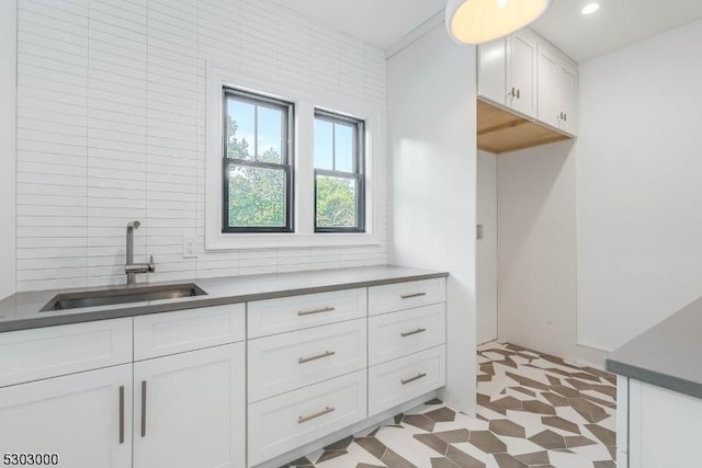 kitchen featuring tile walls, sink, decorative backsplash, and white cabinets