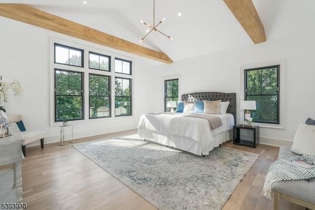 bedroom featuring beamed ceiling, a chandelier, high vaulted ceiling, and light hardwood / wood-style flooring