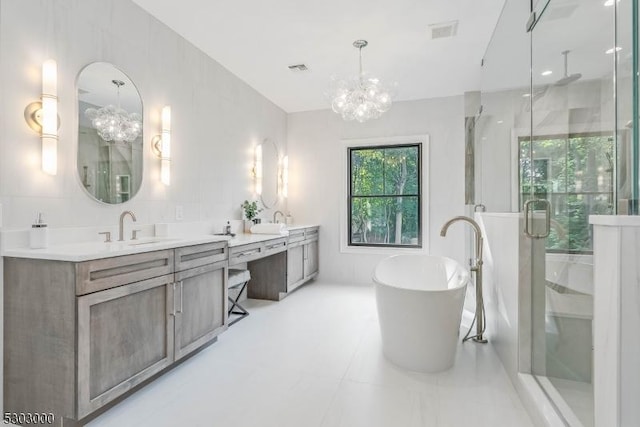 bathroom featuring vanity, a notable chandelier, and separate shower and tub