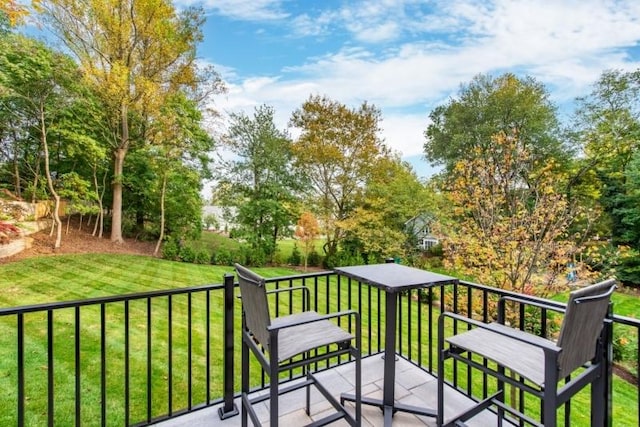 wooden terrace featuring a lawn