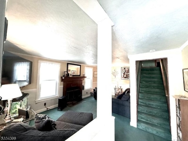 living room with ornamental molding, carpet floors, and a textured ceiling