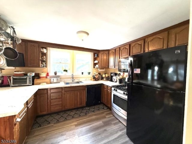 kitchen with sink, dark wood-type flooring, and black appliances