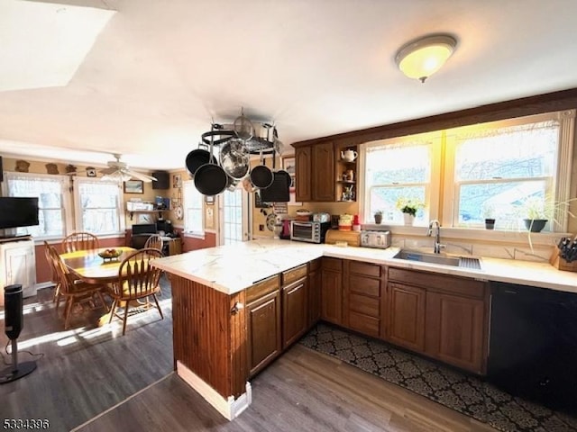 kitchen featuring dishwasher, sink, dark hardwood / wood-style flooring, ceiling fan, and kitchen peninsula