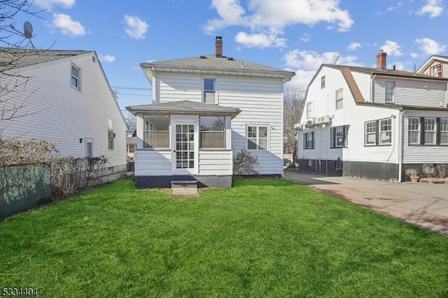 rear view of house featuring a lawn