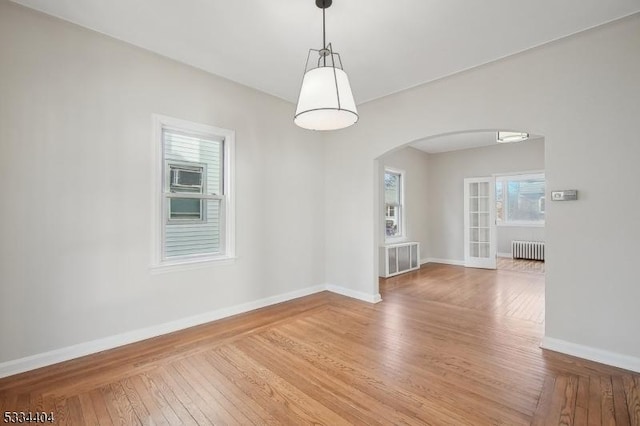 unfurnished dining area featuring hardwood / wood-style flooring and radiator