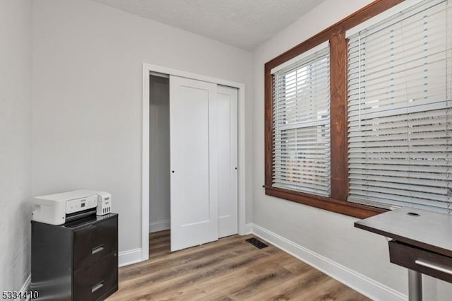 interior space with hardwood / wood-style floors, a closet, and a textured ceiling