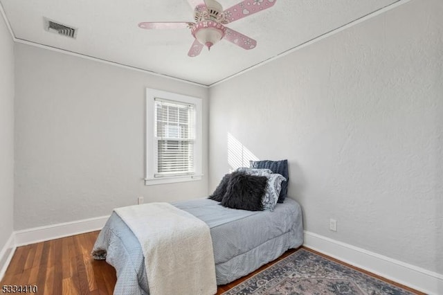 bedroom featuring hardwood / wood-style flooring, ceiling fan, and ornamental molding