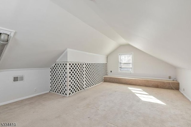 additional living space featuring lofted ceiling and light carpet