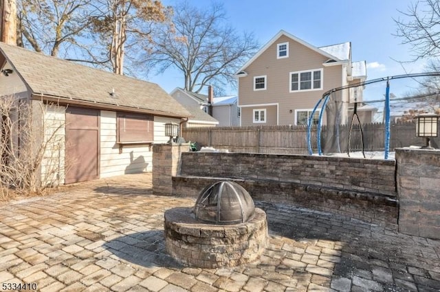 view of patio / terrace with a trampoline and a fire pit