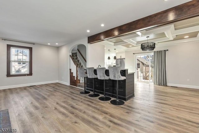 bar with coffered ceiling, hardwood / wood-style floors, beam ceiling, and decorative light fixtures