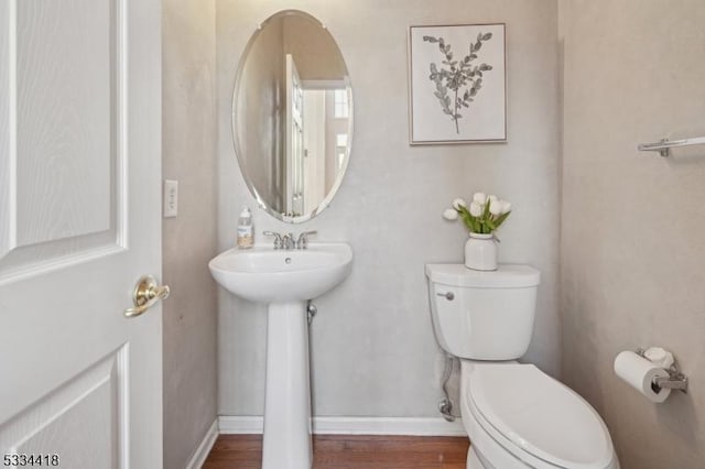 bathroom featuring hardwood / wood-style flooring, toilet, and sink