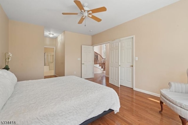 bedroom featuring connected bathroom, hardwood / wood-style floors, and ceiling fan