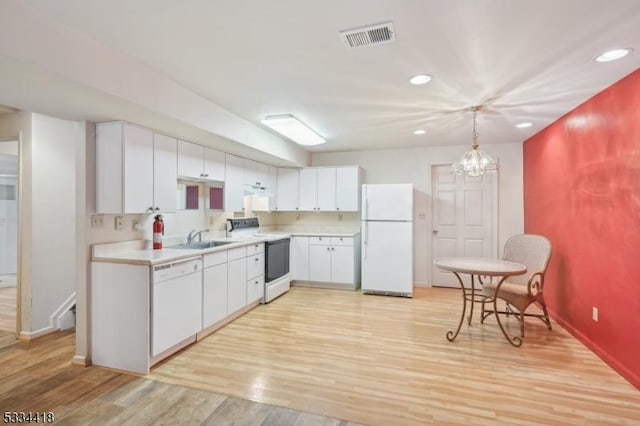 kitchen featuring white cabinetry, white appliances, decorative light fixtures, and sink