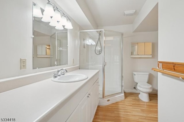 bathroom with hardwood / wood-style flooring, vanity, toilet, and an enclosed shower