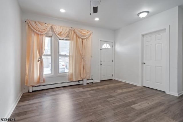 foyer entrance featuring ceiling fan, a baseboard heating unit, and dark hardwood / wood-style floors