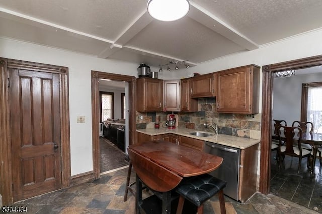 kitchen with tasteful backsplash, dishwasher, sink, and a textured ceiling