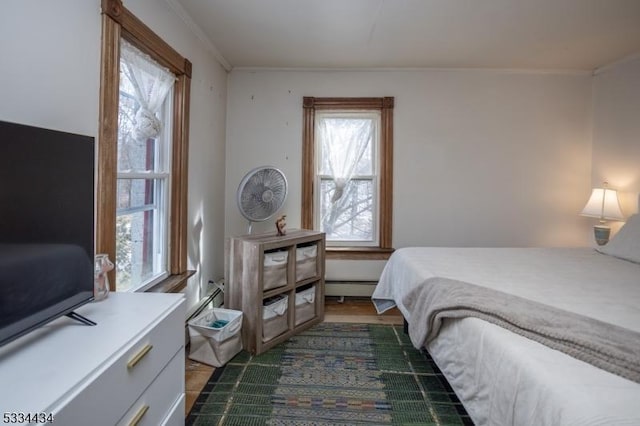 bedroom with crown molding and baseboard heating