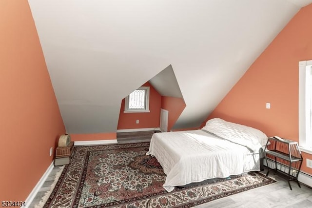 bedroom with lofted ceiling and baseboard heating