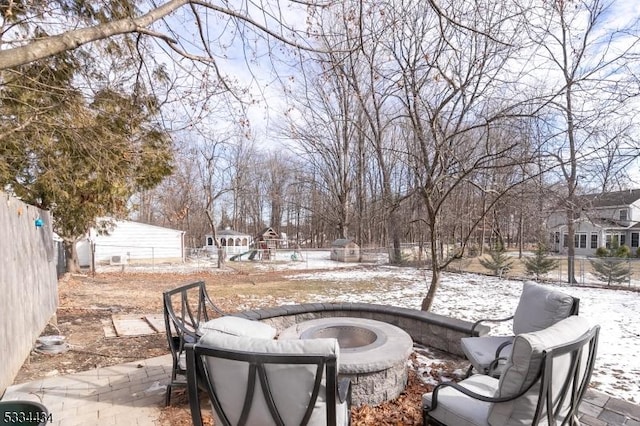 snow covered patio with a fire pit