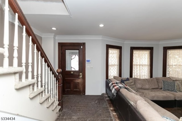 foyer with ornamental molding and a wealth of natural light