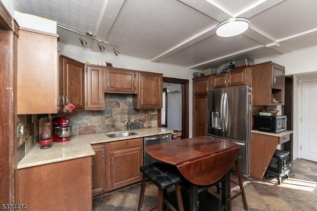 kitchen with sink, decorative backsplash, and appliances with stainless steel finishes