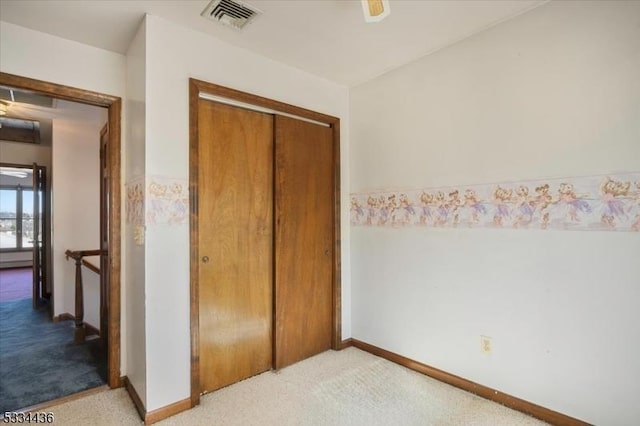 bedroom with baseboards, a closet, visible vents, and light colored carpet