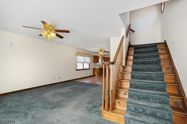 stairway with carpet flooring, ceiling fan, and baseboards