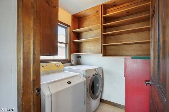 clothes washing area with laundry area, independent washer and dryer, and baseboards