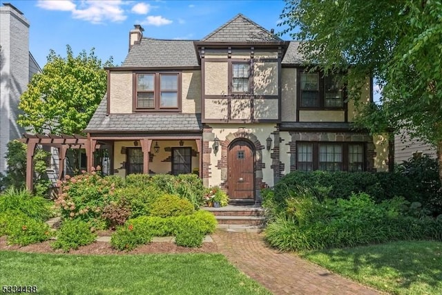 view of front of property featuring a pergola, a high end roof, a chimney, and stucco siding