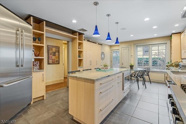 kitchen with visible vents, a kitchen island, built in appliances, pendant lighting, and open shelves