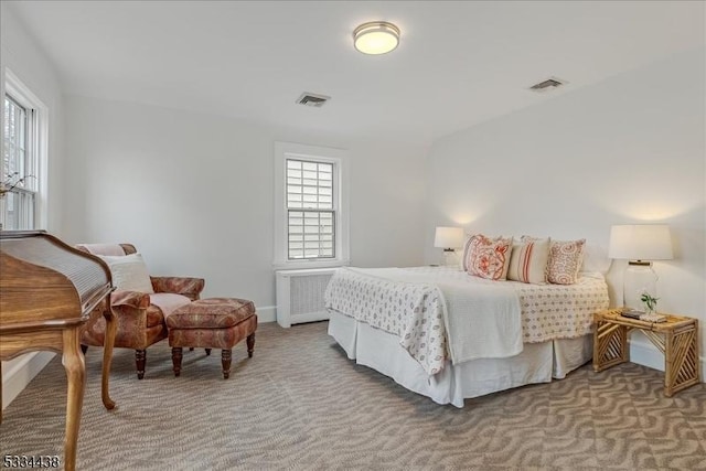 carpeted bedroom featuring radiator heating unit and visible vents