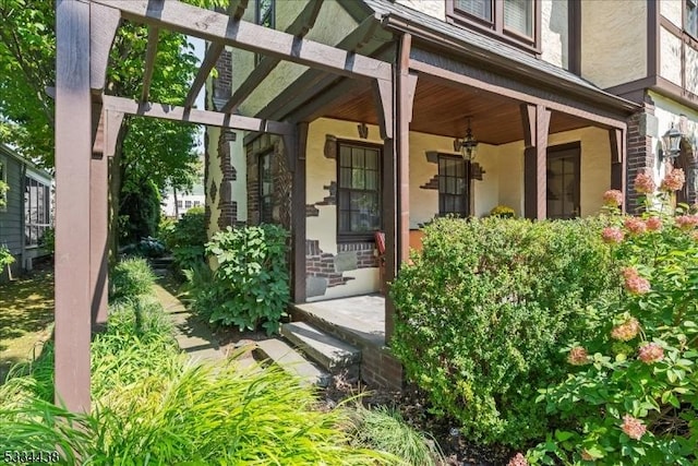 entrance to property with a porch and stucco siding