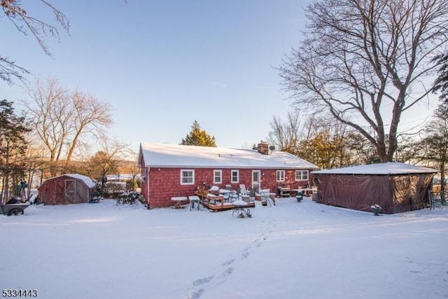 view of snow covered back of property