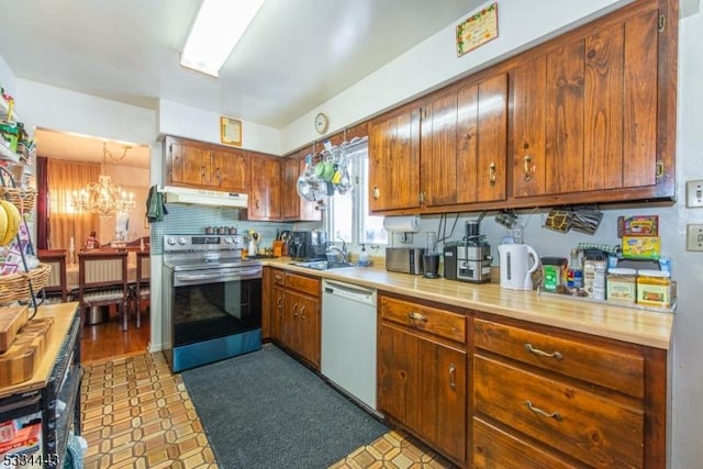 kitchen featuring stainless steel range with electric stovetop, white dishwasher, a chandelier, and sink