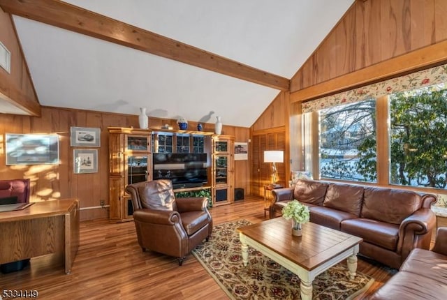 living room featuring hardwood / wood-style floors, lofted ceiling with beams, and wood walls