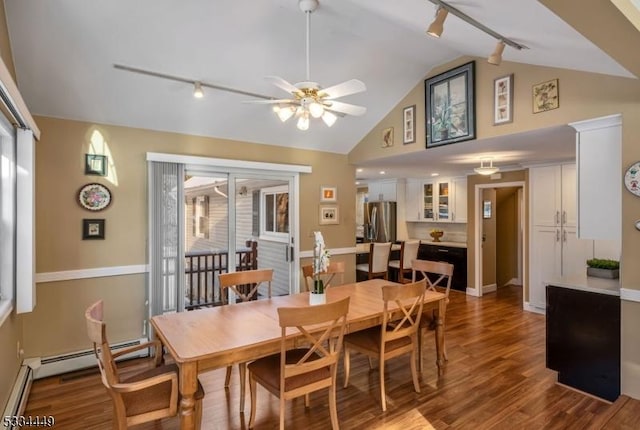 dining space with lofted ceiling, baseboard heating, track lighting, hardwood / wood-style flooring, and ceiling fan