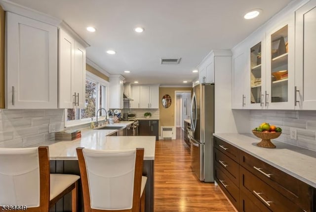 kitchen featuring appliances with stainless steel finishes, a kitchen breakfast bar, kitchen peninsula, and sink