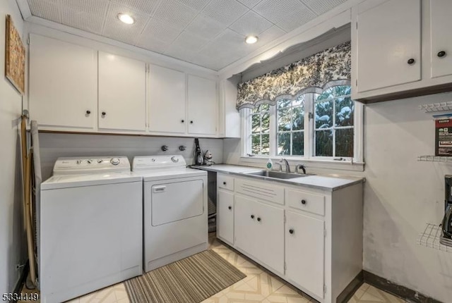 laundry area featuring cabinets, separate washer and dryer, and sink