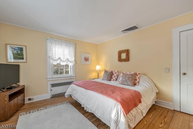 bedroom featuring wood-type flooring and radiator